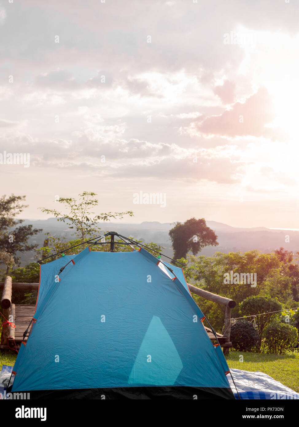 Camping blue tent on green grass with the mountain and sunset sky view ...
