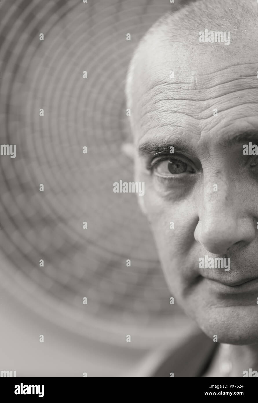 A Man Is Posing With Naked Torso And Vest A Wheel Of A Fan Coil Is On The Background Stock