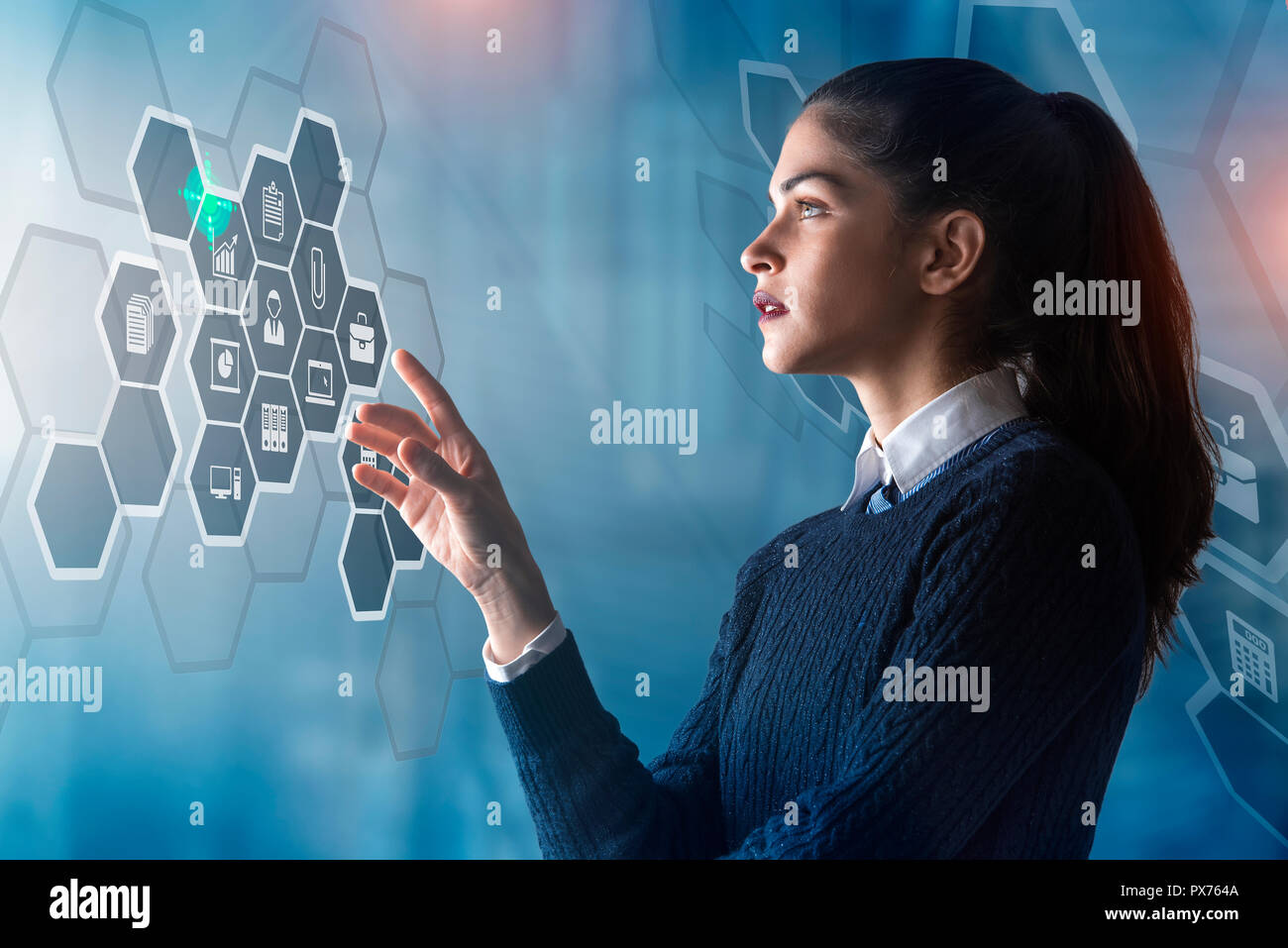 modern business woman using innovative technologies to manage her administrative work, analyzing a digital projected graph Stock Photo