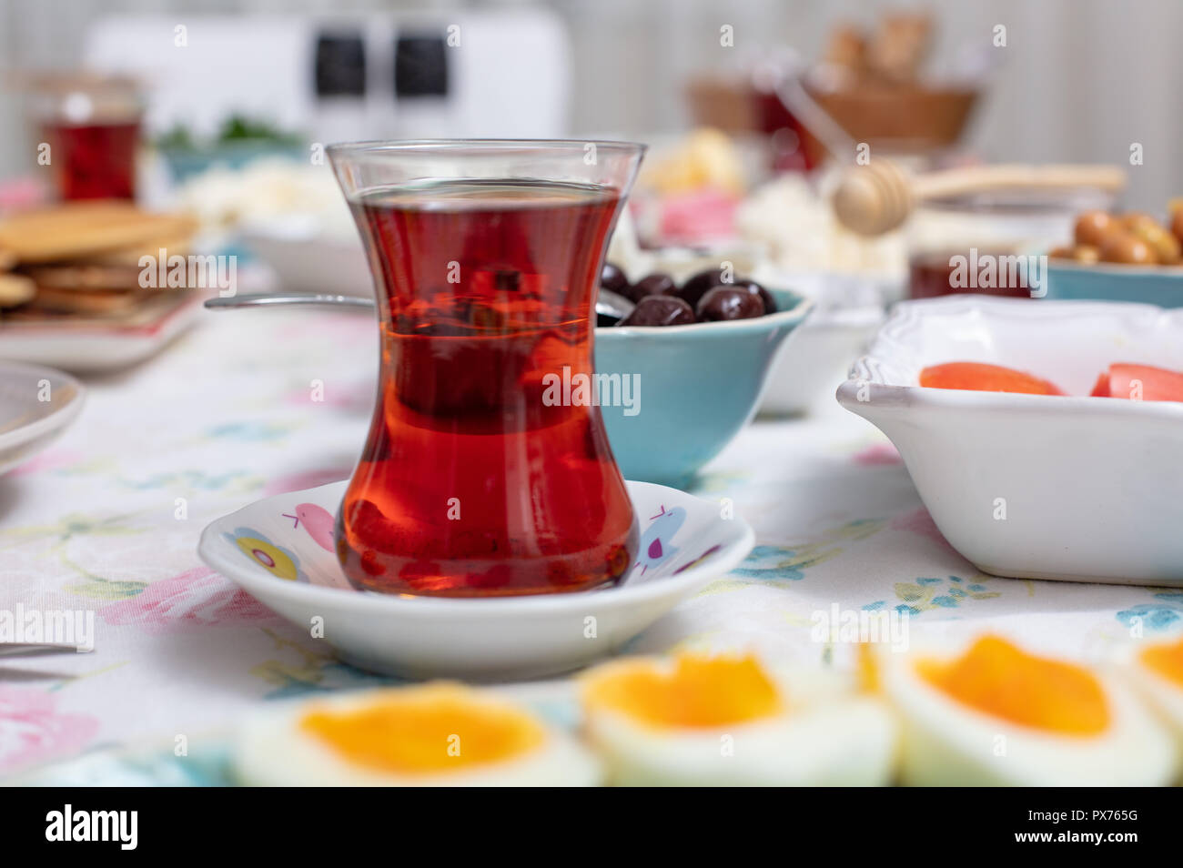 Turkish breakfast with simit (bagel) pancake, cheese, cherry tomato, cucumber, and tea on a table close up view, selective focus Stock Photo