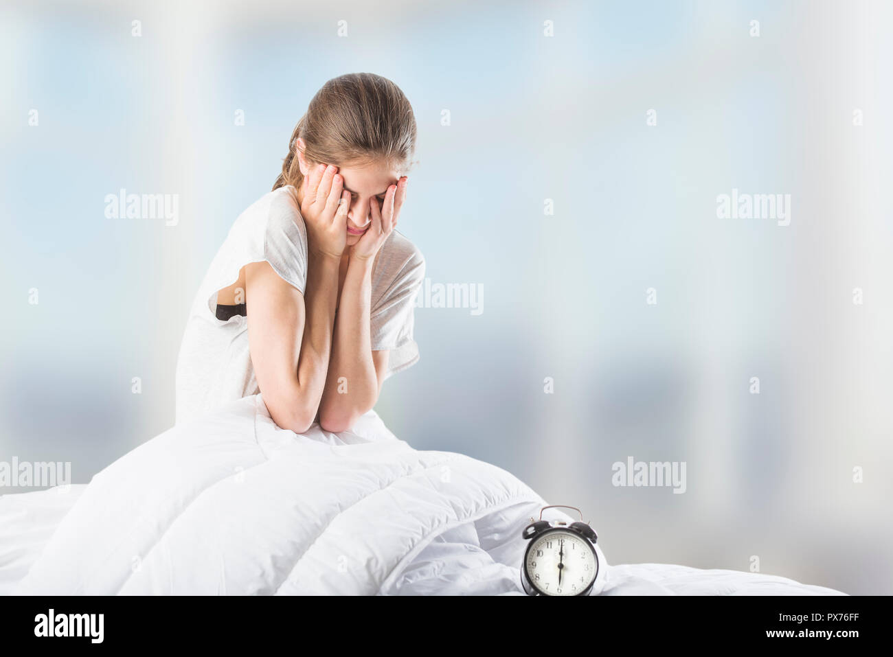 a beautiful young woman in bed, rubbing her eyes after her morning wake up Stock Photo