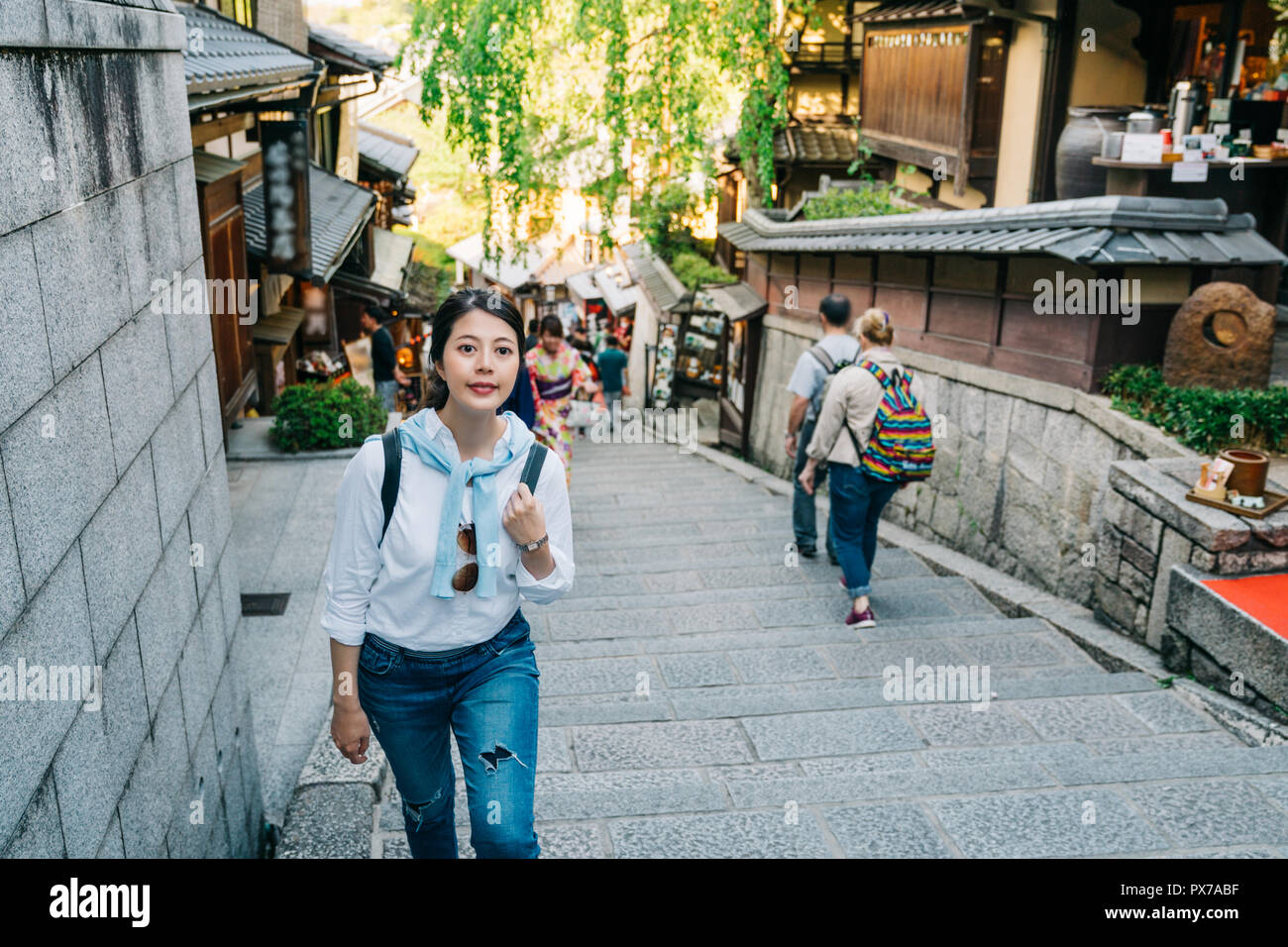 elegant female tourist traveling alone and walking up the stairs in Sannen street. backpacker visit Kyoto in self-guided trip in Japan. vacation in su Stock Photo