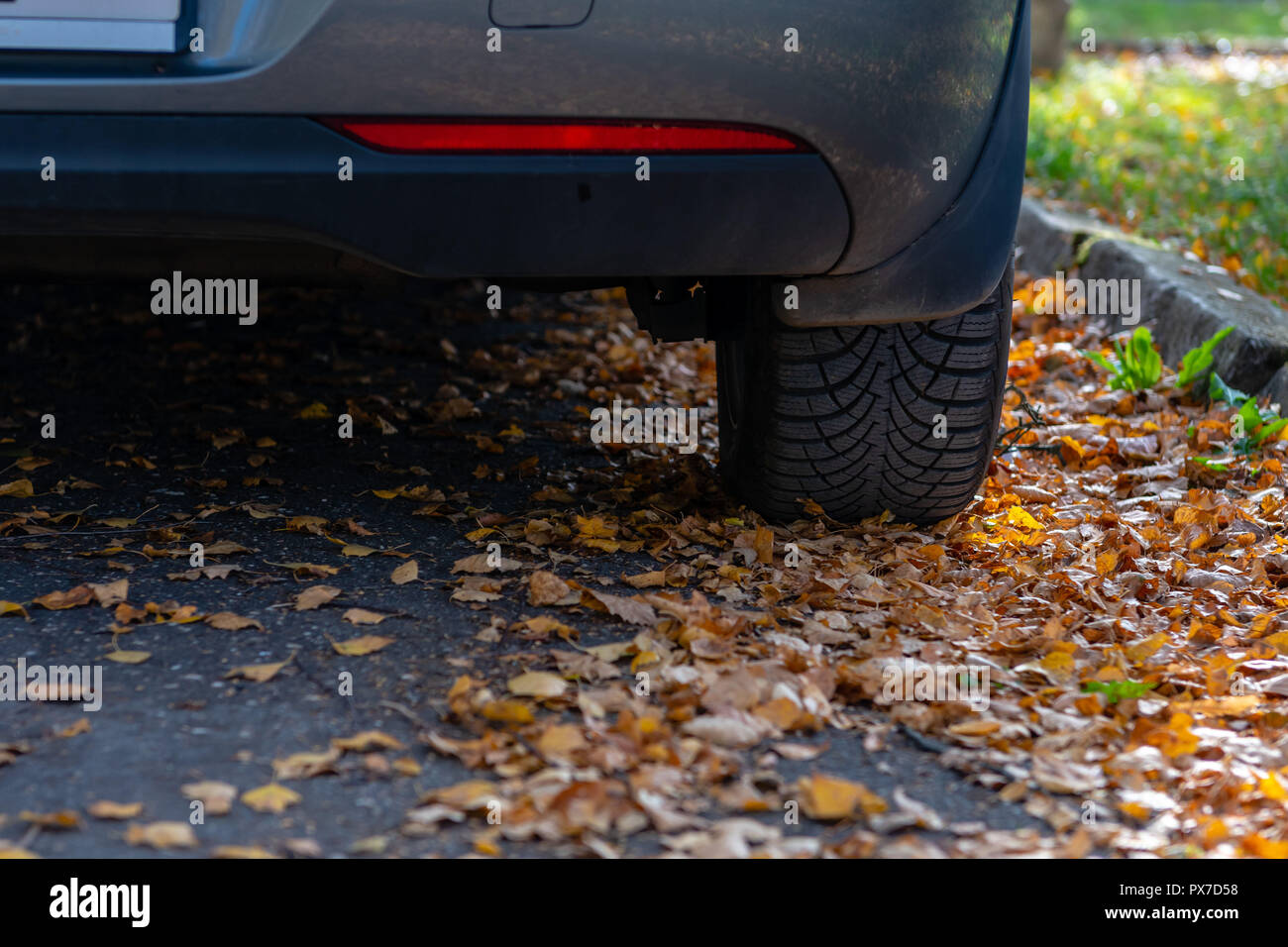 Season tire change. Car with new winter tires on the road for autumn