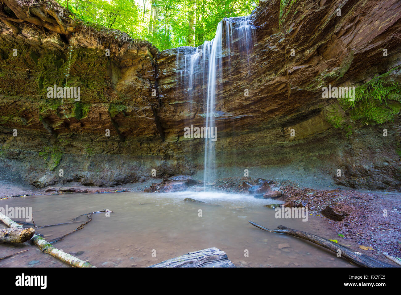 Germany, Beautiful mystic waterfall over green moss covered rocks Stock