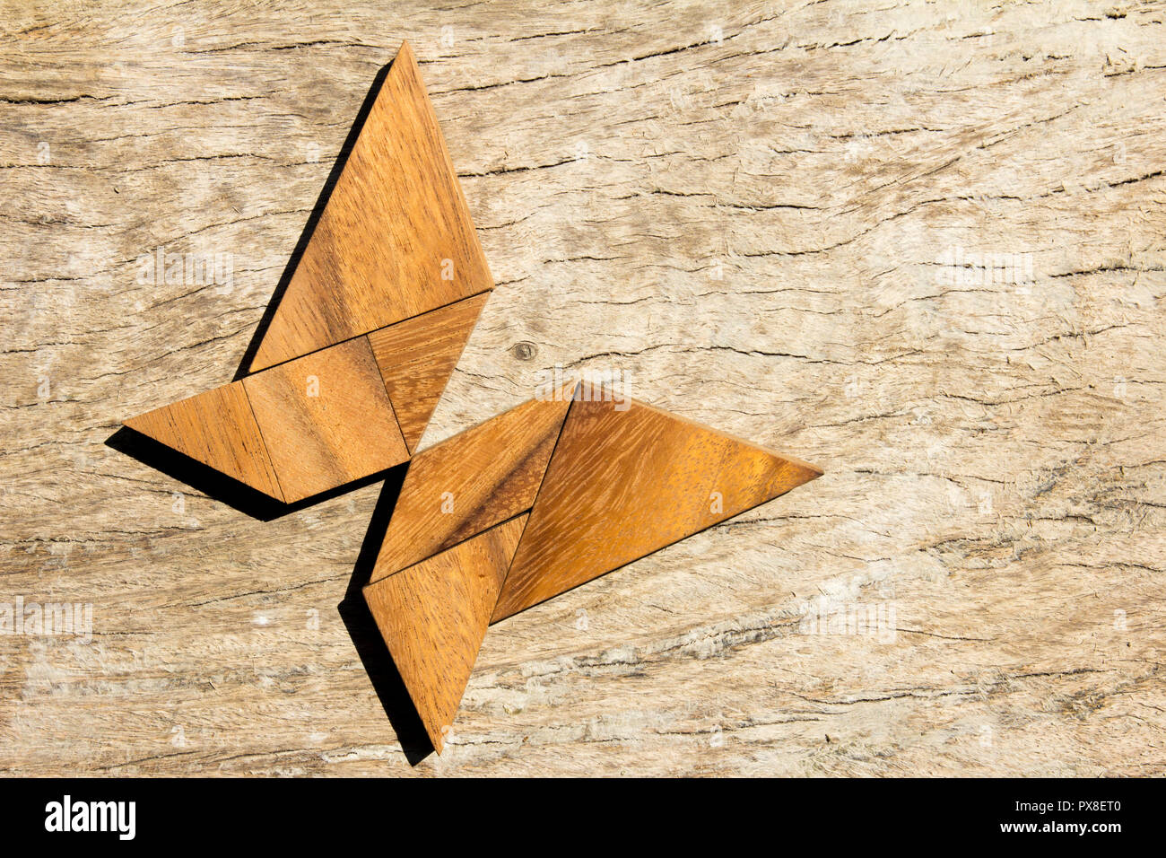 Wooden tangram puzzle in flying butterfly shape background Stock Photo