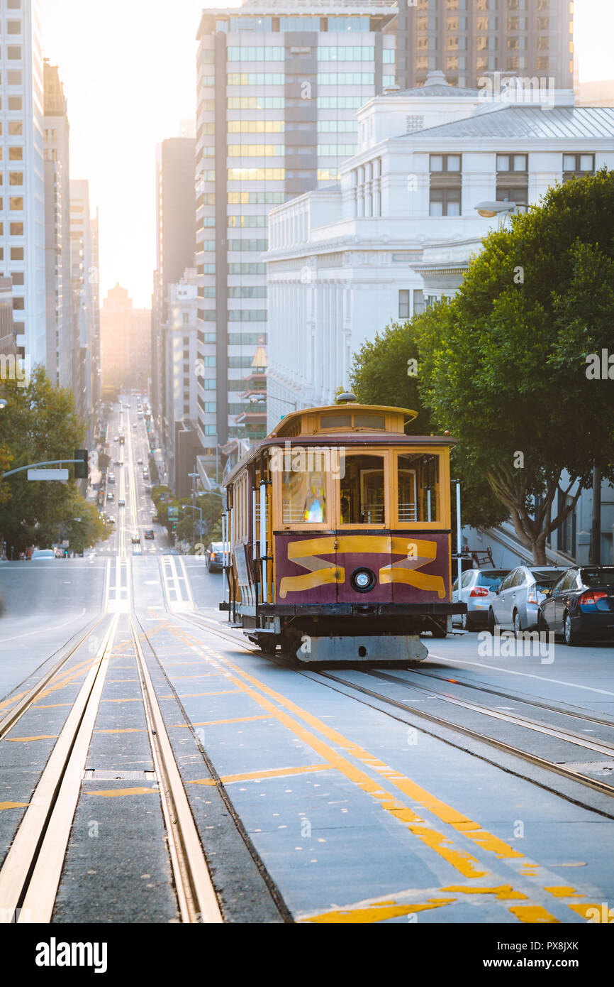 Historic Cable Cars riding on famous California Street in beautiful golden morning light at sunrise, San Francisco, California, USA Stock Photo