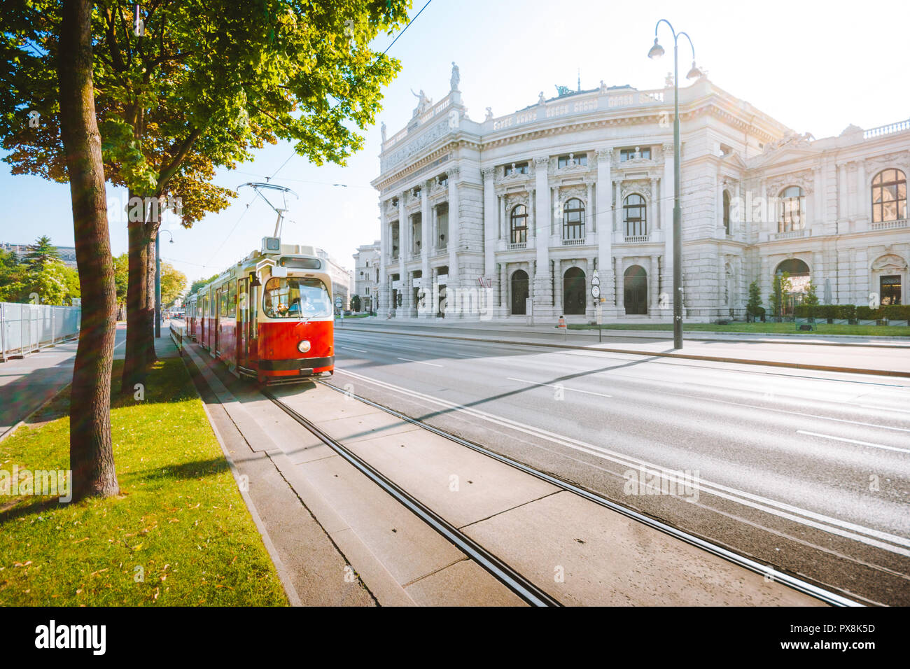 Famous Wiener Ringstrasse with historic Burgtheater (Imperial Court Theatre) and traditional red electric tram at sunrise, Vienna, Austria Stock Photo