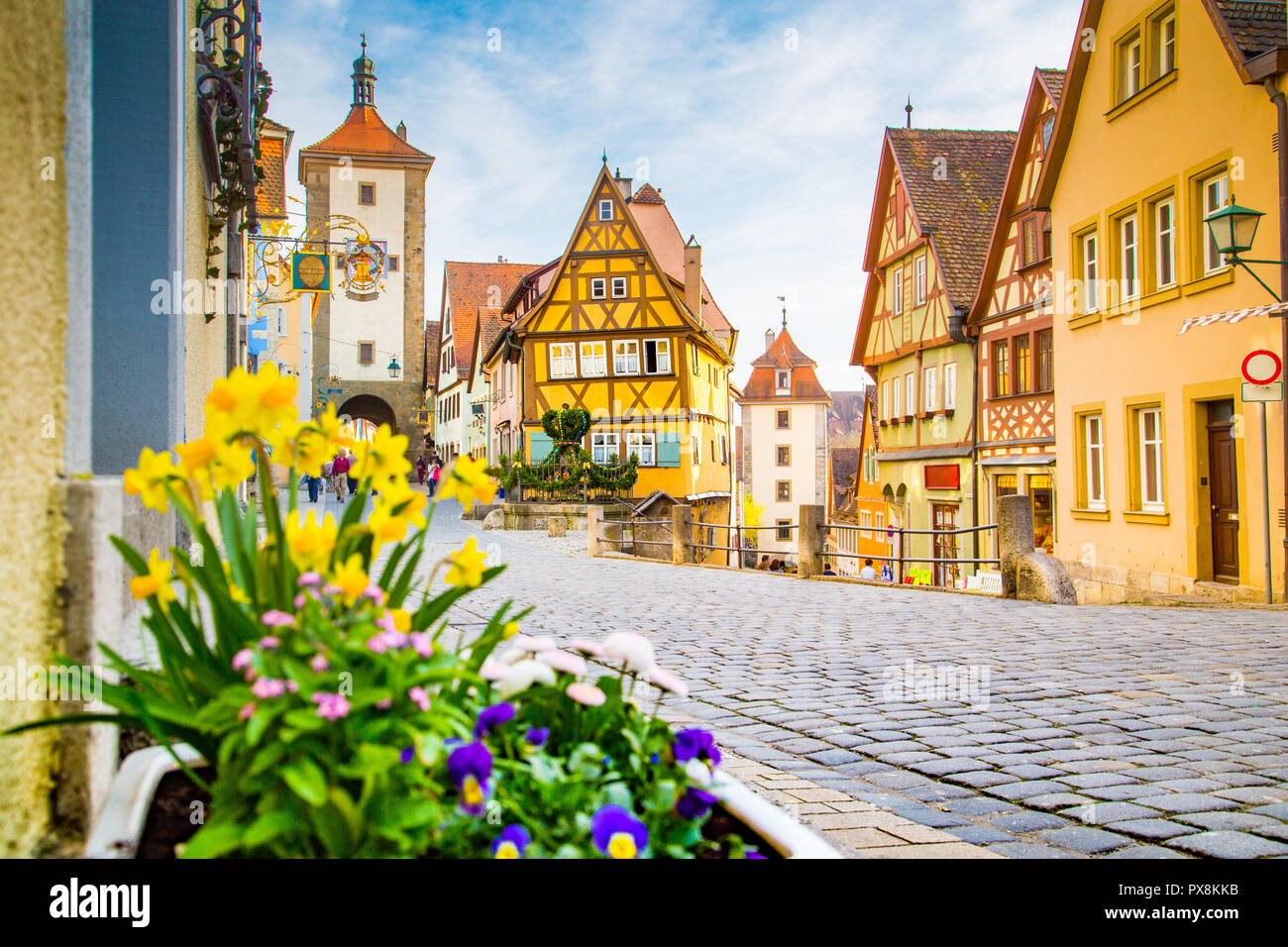 Classic view of the medieval town of Rothenburg ob der Tauber with blooming flowers on a beautiful sunny day with blue sky and clouds in springtime Stock Photo