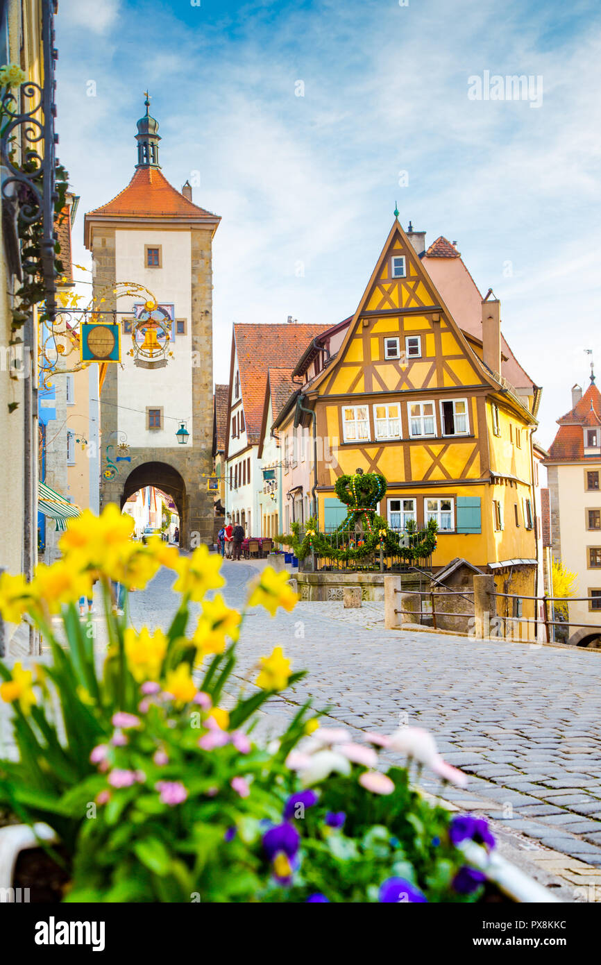 Classic view of the medieval town of Rothenburg ob der Tauber with blooming flowers on a beautiful sunny day with blue sky and clouds in springtime Stock Photo