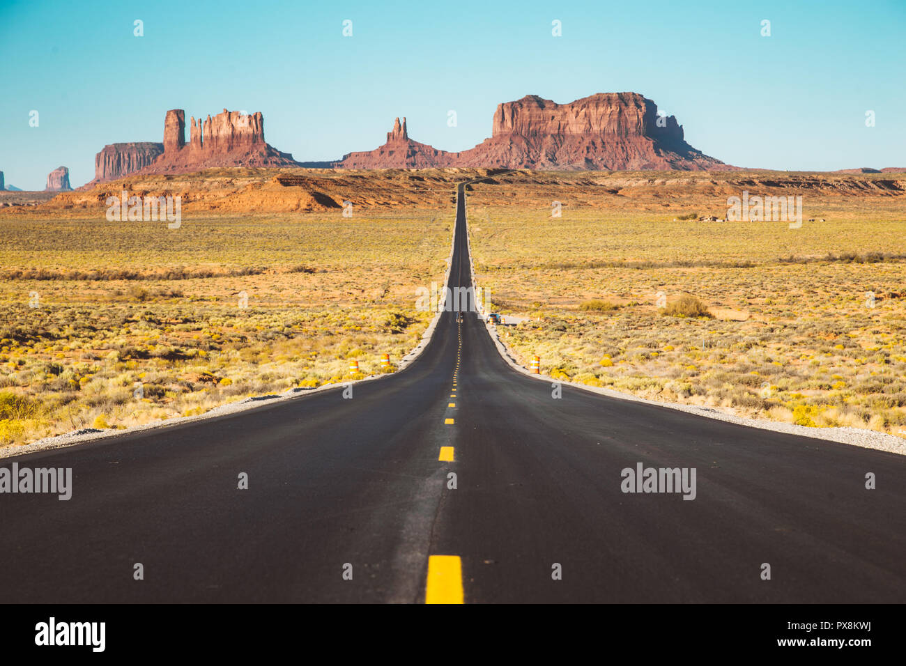 Classic panorama view of historic U.S. Route 163 running through famous Monument Valley in beautiful golden evening light at sunset in summer, Utah, U Stock Photo