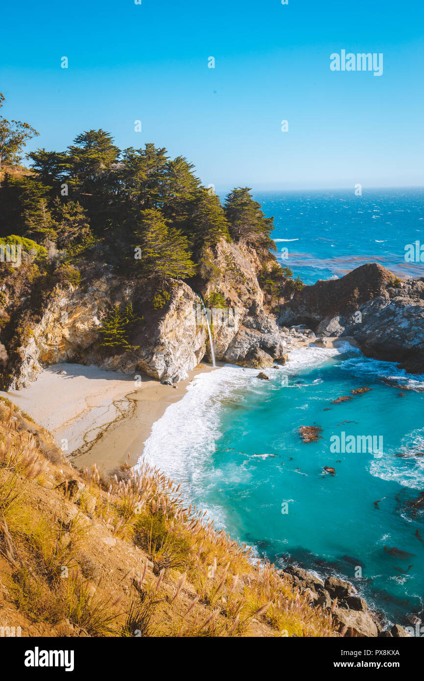 Classic postcard view of famous McWay Falls in scenic golden evening light at sunset on a beautiful sunny day with blue sky in summer, California, USA Stock Photo