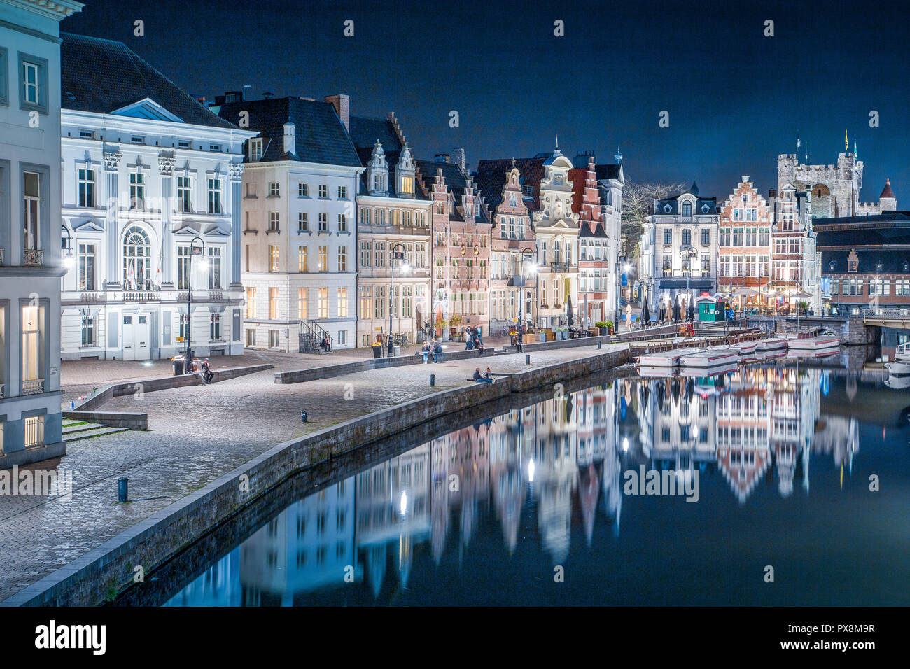 Panoramic view of famous Korenlei in the historic city center of Ghent illuminated in beautiful post sunset twilight during blue hour at dusk with Lei Stock Photo
