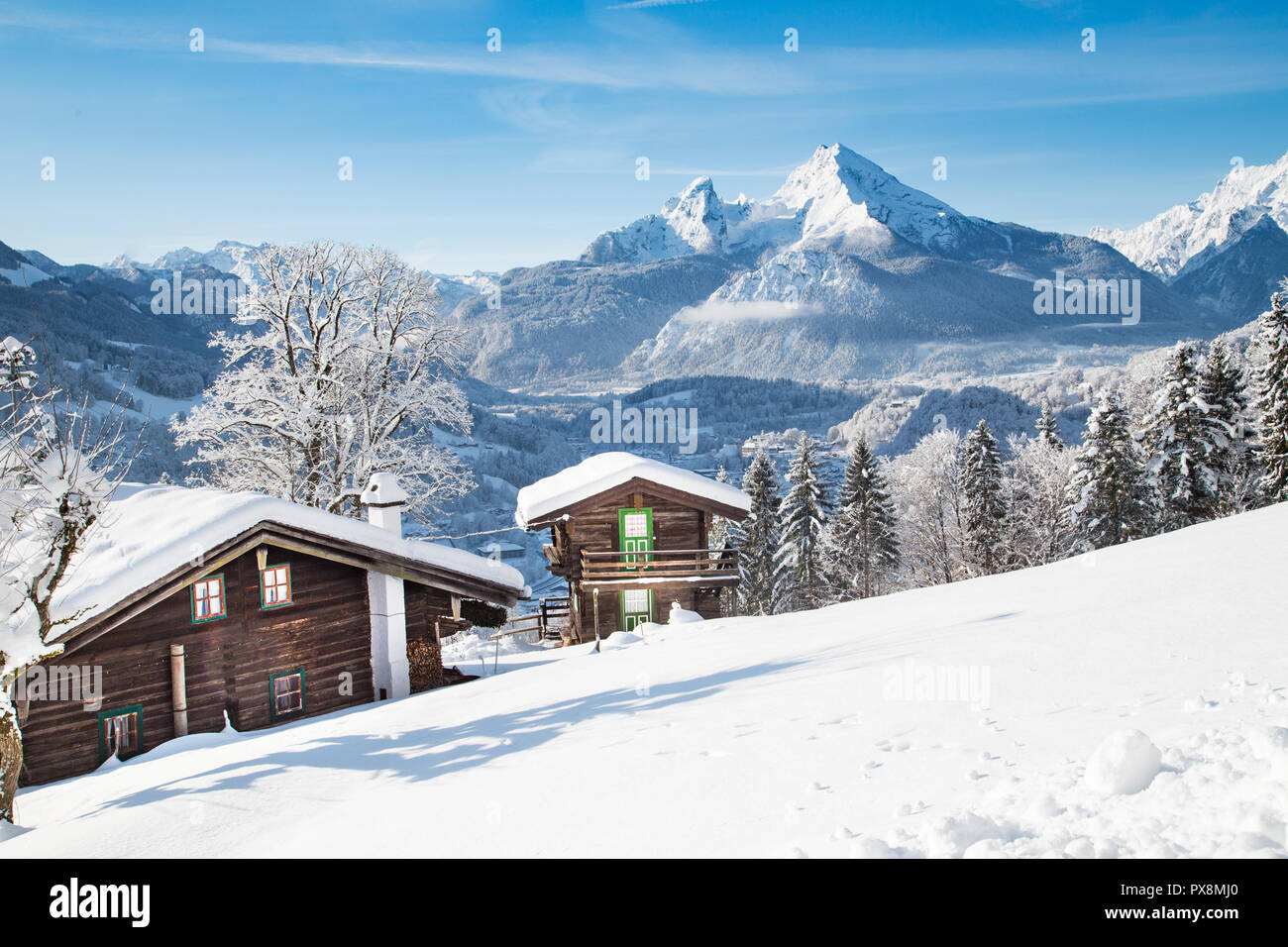 Beautiful view of traditional wooden mountain cabins in scenic winter wonderland mountain scenery in the Alps Stock Photo