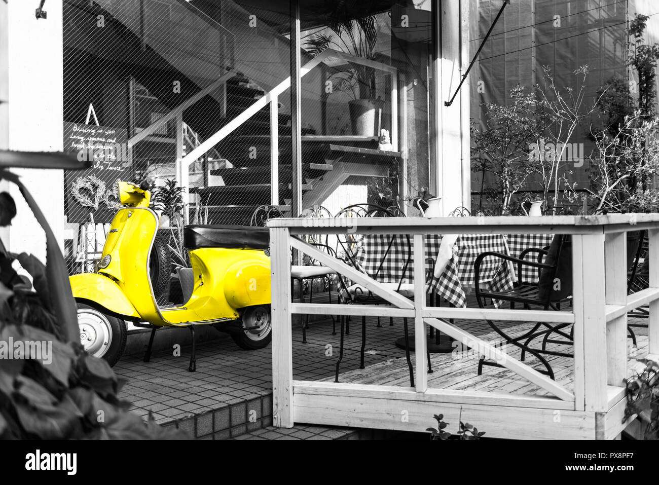 Yellow Vespa scooter at monochrome cafe Stock Photo