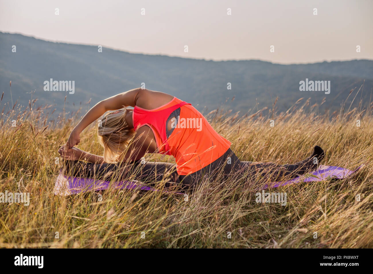 Woman Doing Yoga In The Nature Parivrtta Janu Sirsasana Revolved Head To Knee Pose Stock Photo Alamy