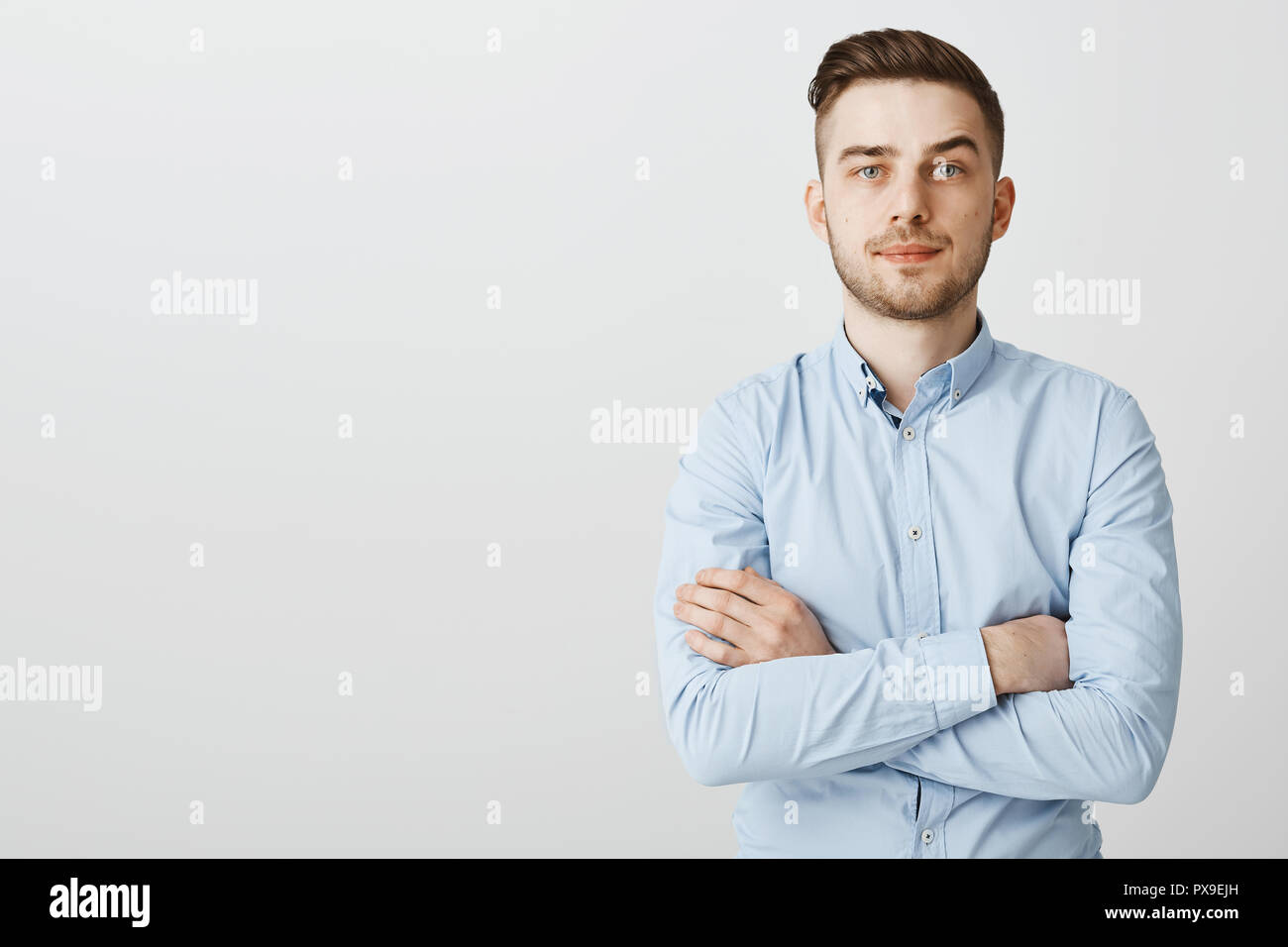 Smart ambitious and seriouslooking young businessman in blue collar