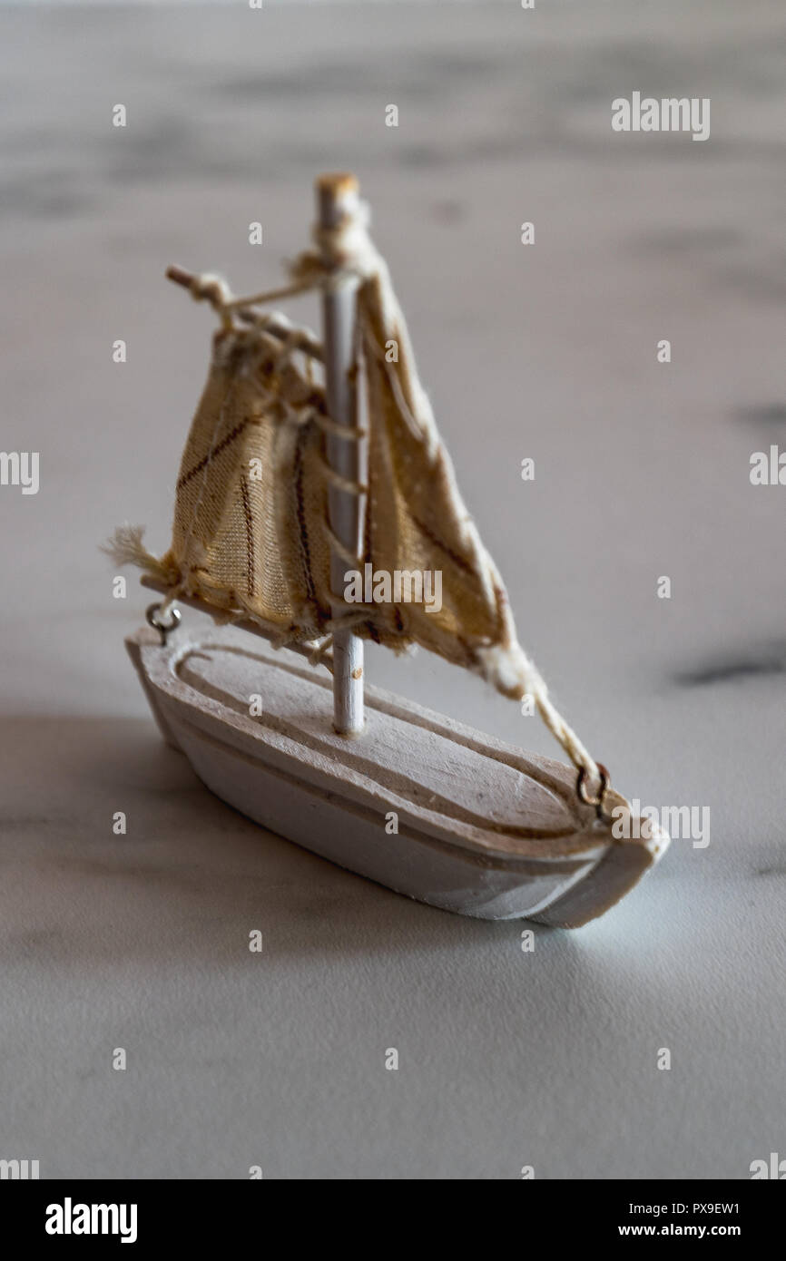 little white sailboat decoration on a marble plate closeup Stock