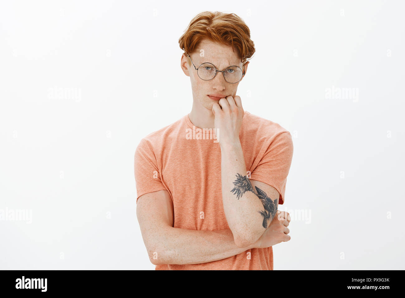 Indoor Shot Of Serious Handsome And Thoughtful Tattooed Male With