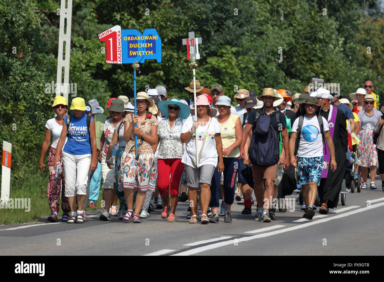 Group of pilgrims walk on the road during pilgrimage to the Monastery of Jasna Gora in Czestochowa, Poland for the annual feast of Assumption of Mary. Stock Photo