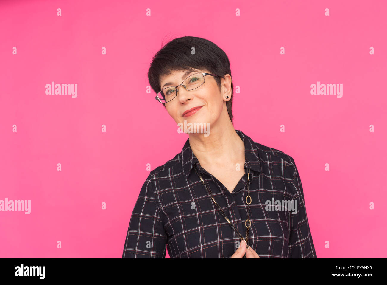 Fashion and people concept - Portrait of middle-aged woman in glasses with  short hair standing on pink background Stock Photo - Alamy