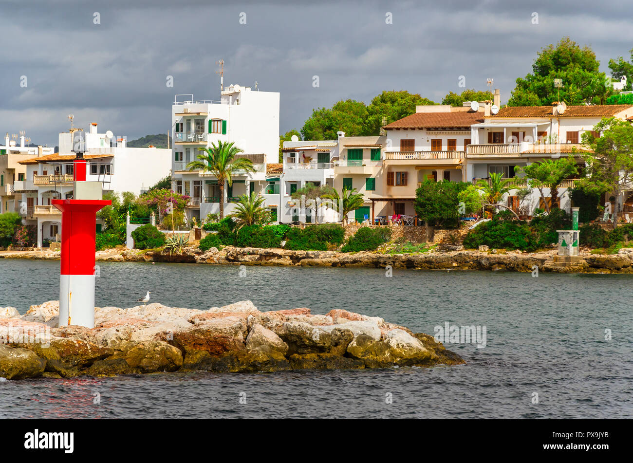 Buildings an navigational light at the harbour of Porto Petro, Mallorca. Stock Photo