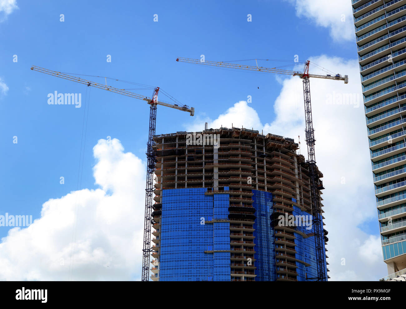 Construction industry image of tall cranes and building exterior in ...