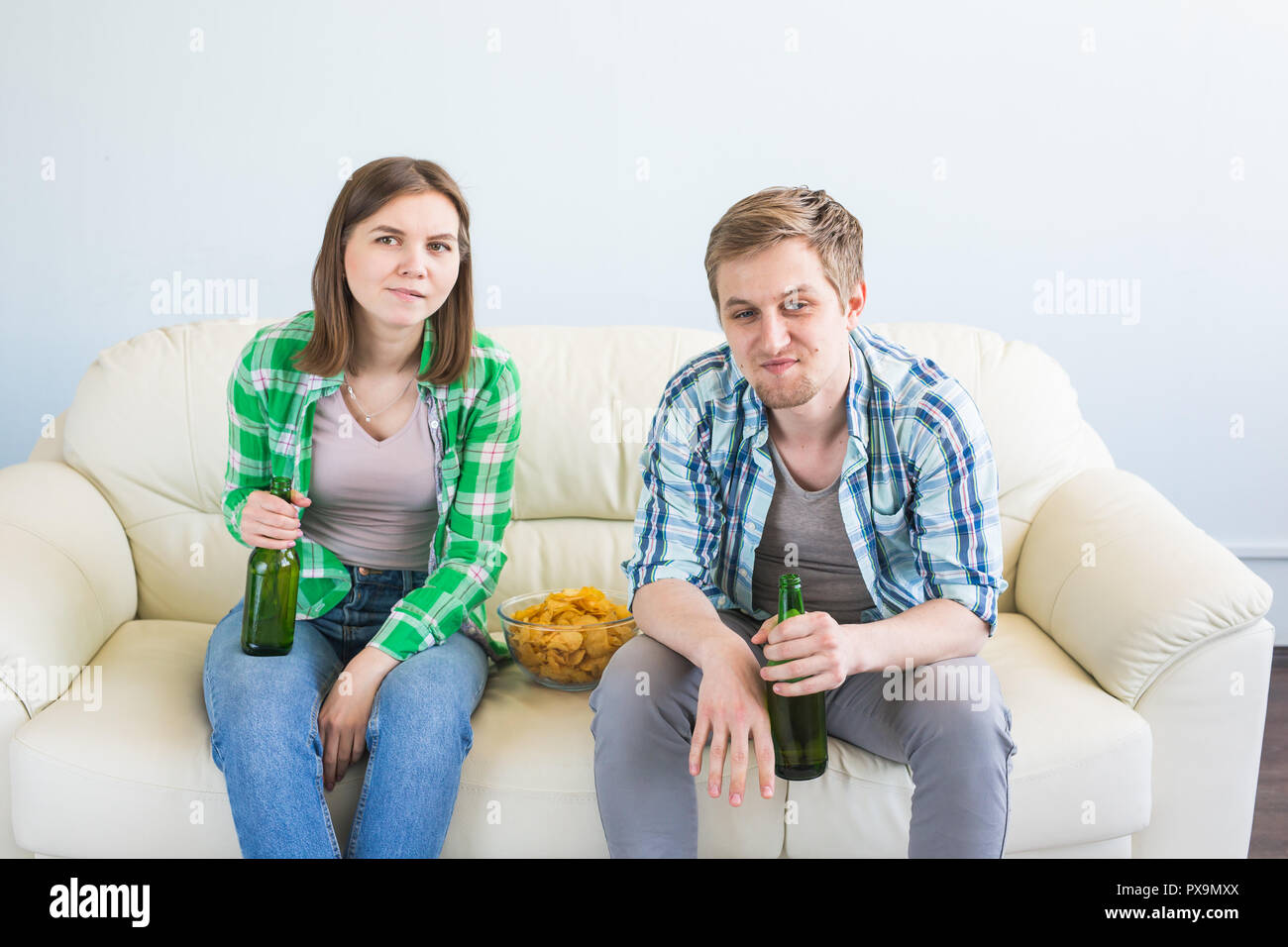 Friends watch sports on TV together, drink beer. Fans cheer for their team. Stock Photo