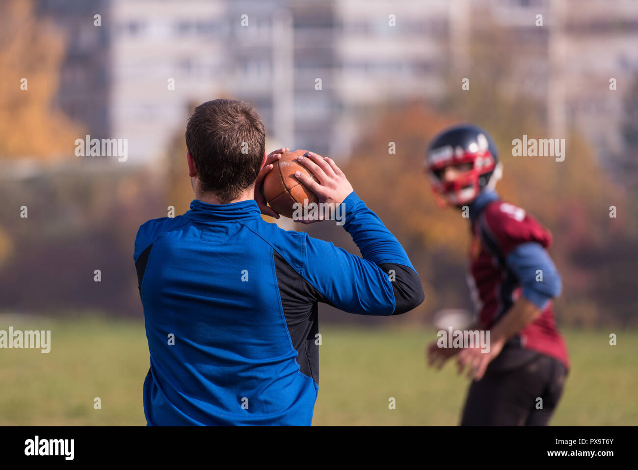 Team coach throwing the ball into the group of young american football