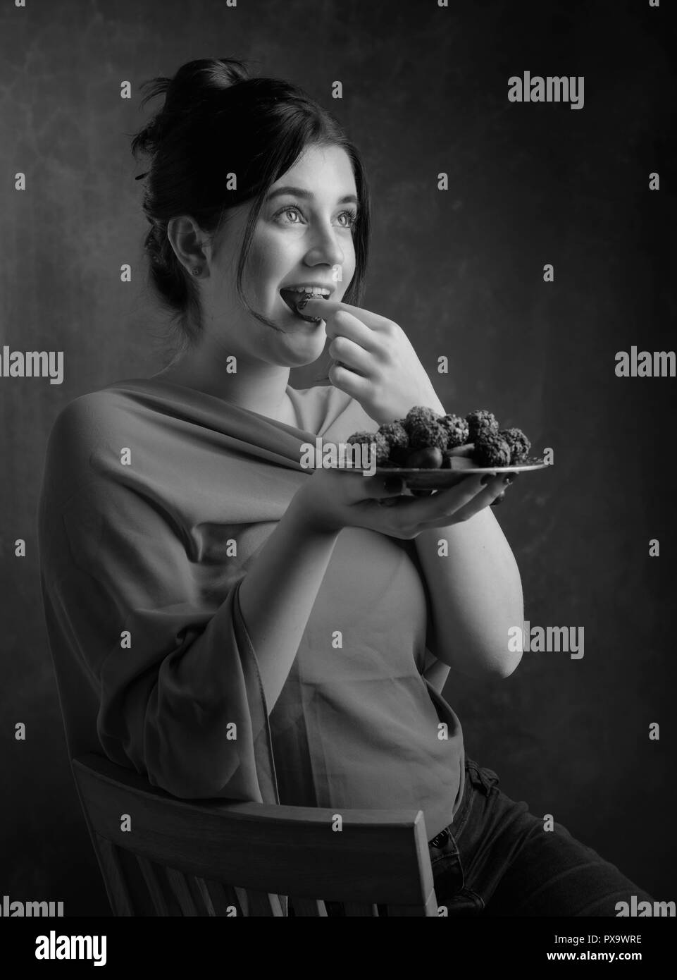 Portrait of a young beautiful girl with chocolate and candy. Black and white. Stock Photo