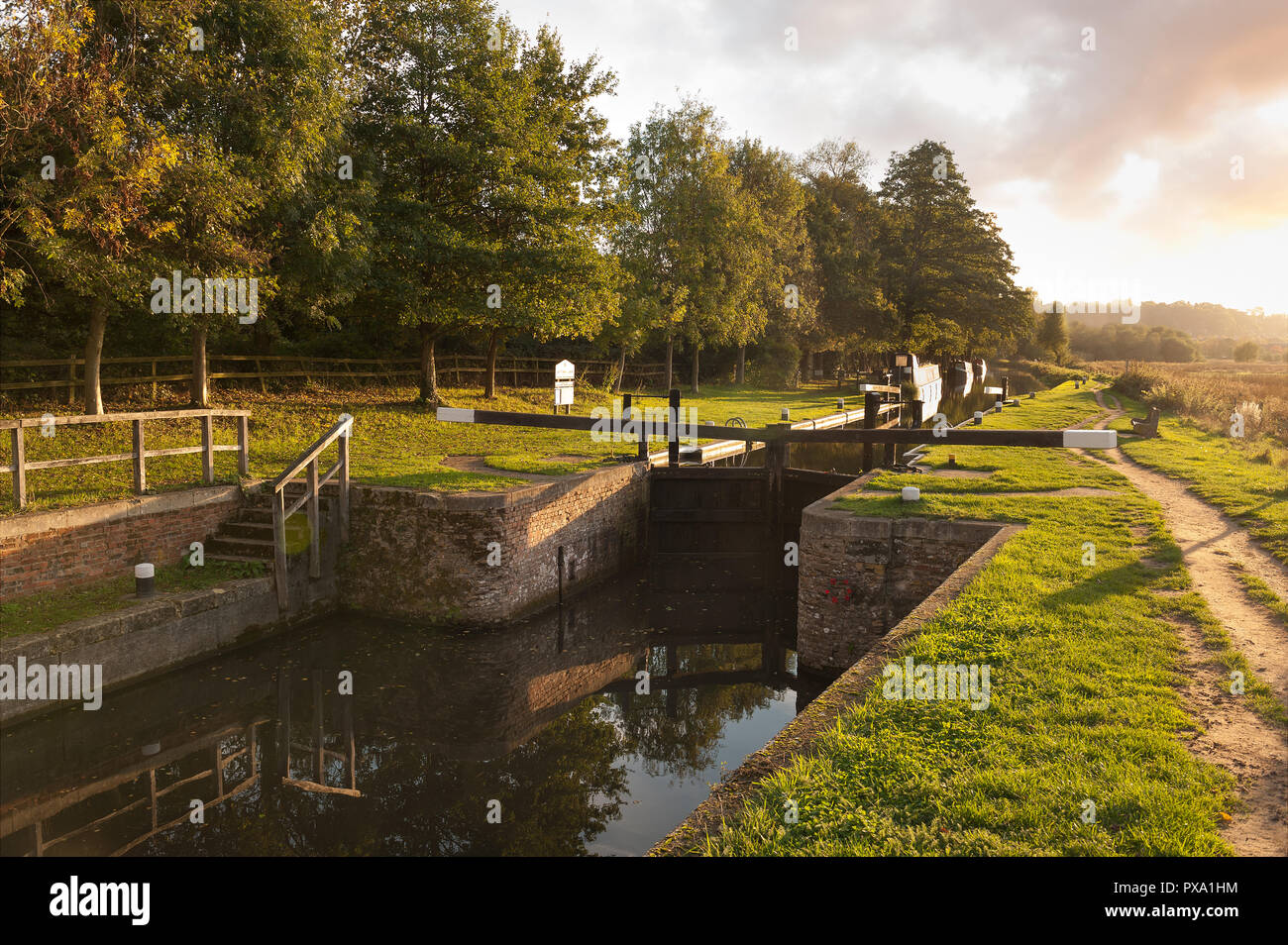 Catteshall Lock on the River Wey, Godalming, at sunset on a lovely summers evening, with calm canal waters Stock Photo