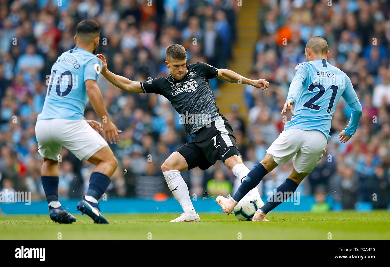 Burnley's Johann Gudmundsson (centre) in action against Manchester City's Sergio Aguero (left) and Manchester City's David Silva during the Premier League match at the Etihad Stadium, Manchester. Stock Photo