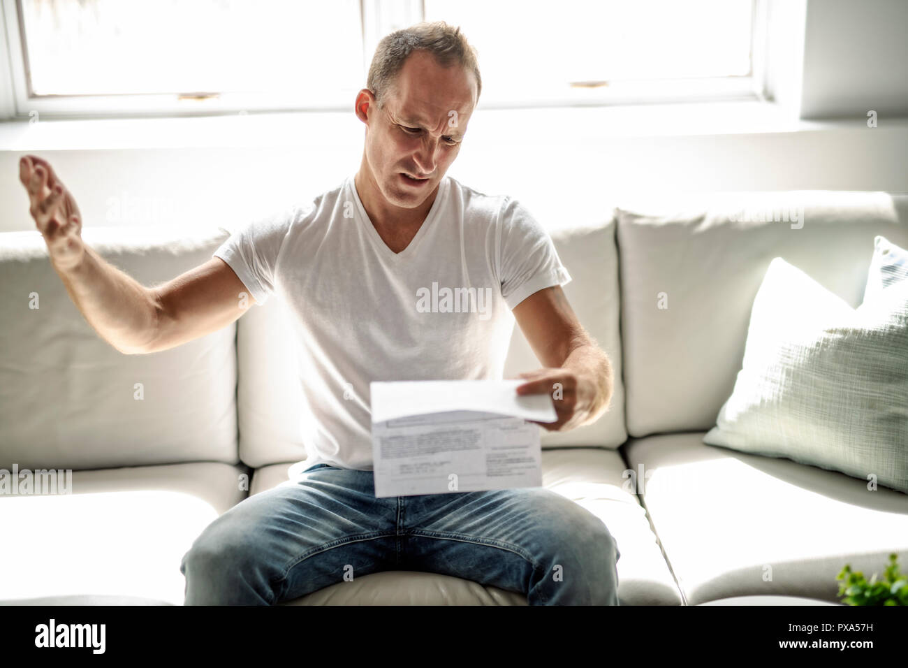 A bad news. Depressed mature man holding paper Stock Photo