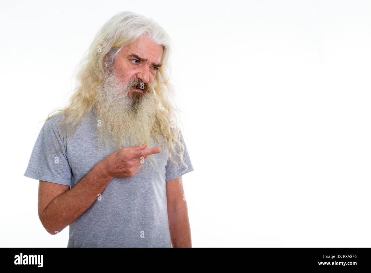 Studio shot of disgusted senior bearded man looking and pointing Stock Photo