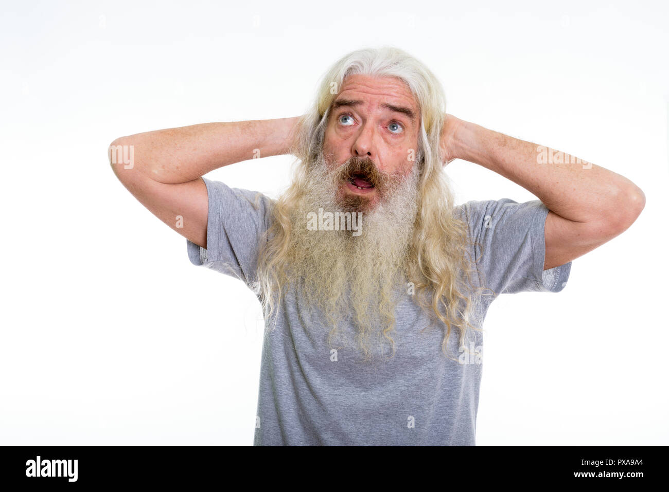 Studio shot of senior bearded man thinking while looking shocked Stock Photo