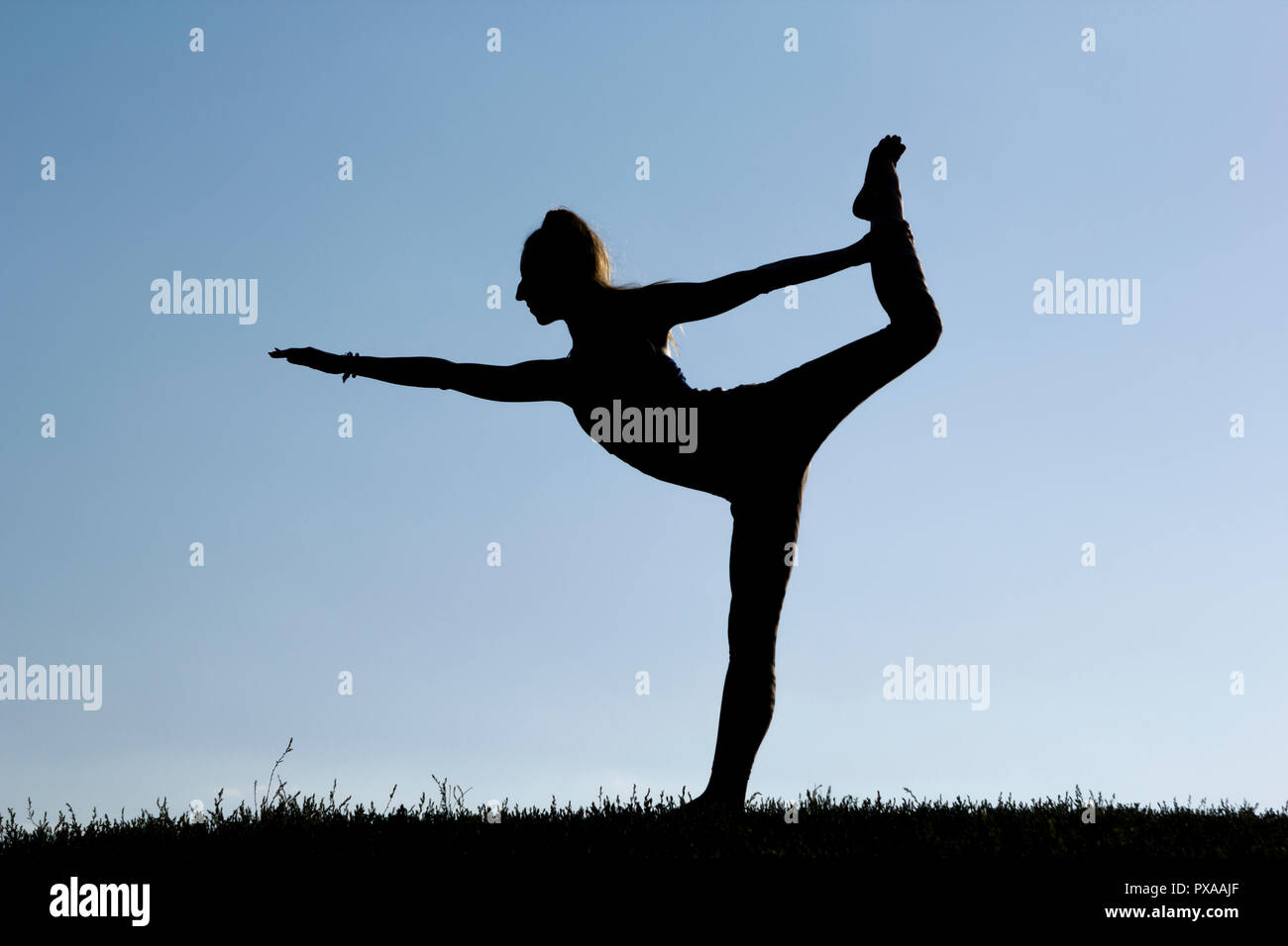 A young woman is meditating in nature. Girl doing yoga in the park. Healthy lifestyle. Stock Photo