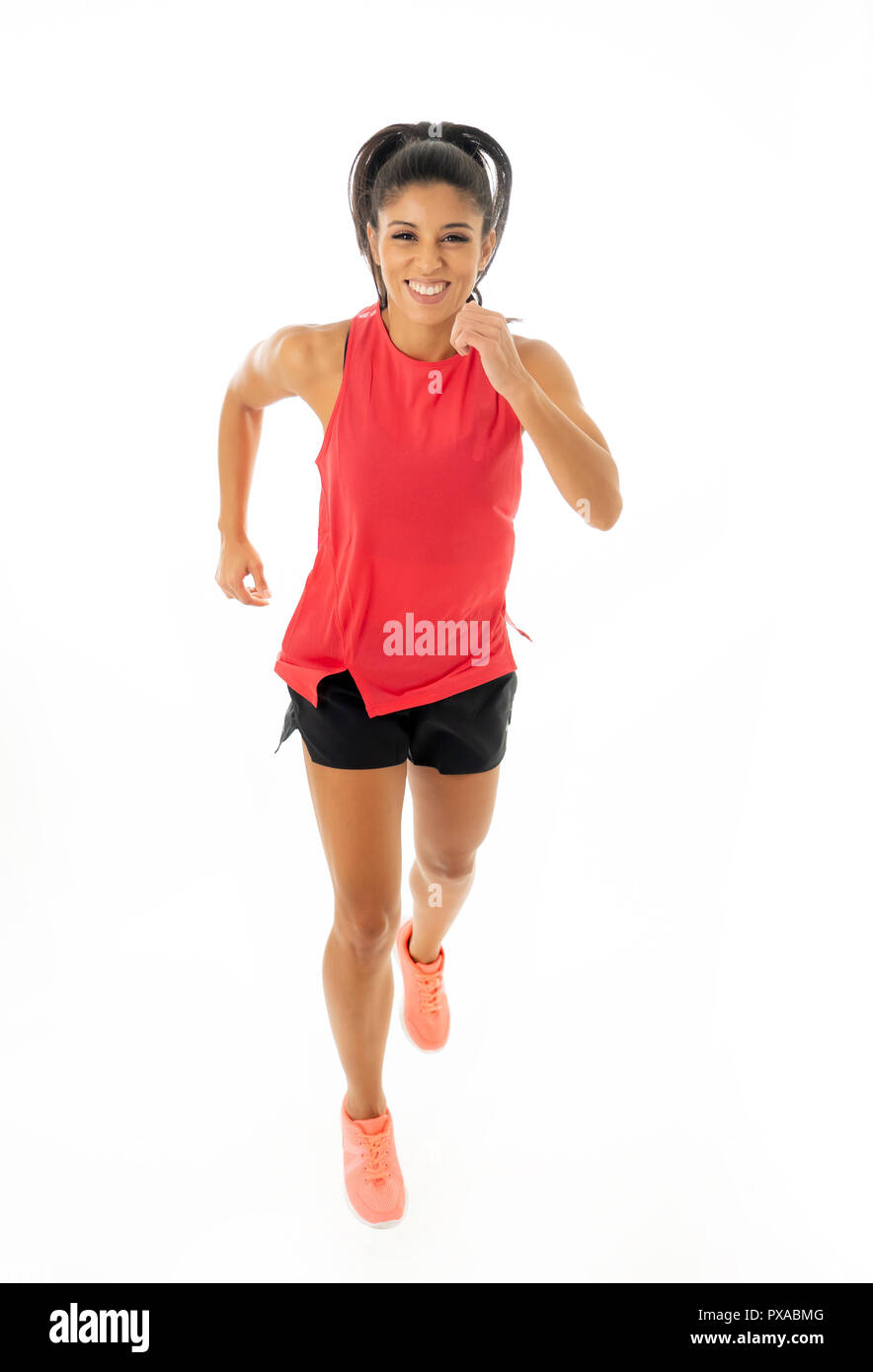 Young attractive happy latin woman in sport clothes with beautiful smile running and training on jogging workout isolated on white background in fitne Stock Photo