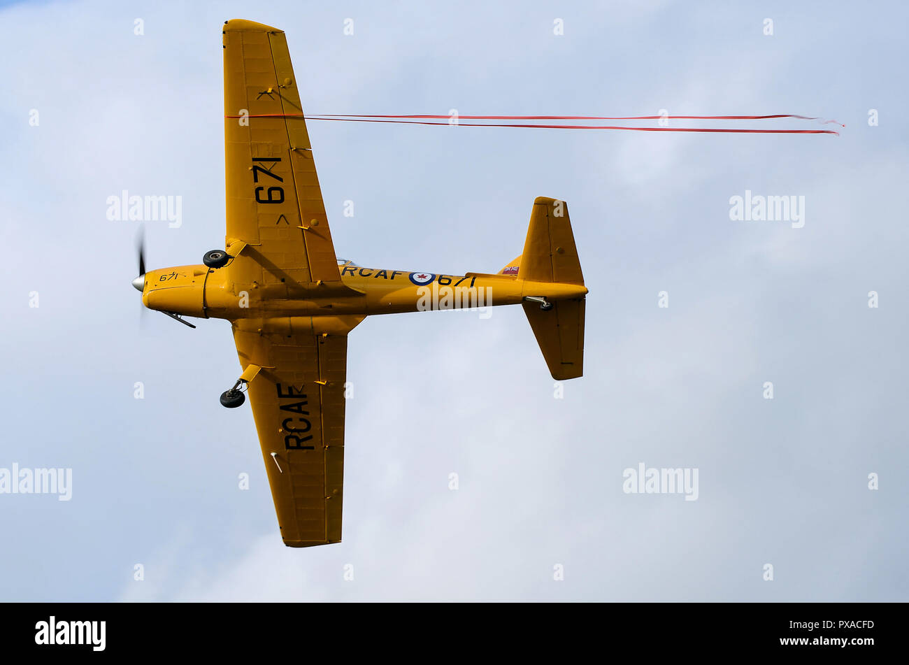 de Havilland Canada Chipmunk T22 in Royal Canadian Air Force yellow colours. Flying at Shuttleworth airshow with ribbon from stunt. Space for copy Stock Photo