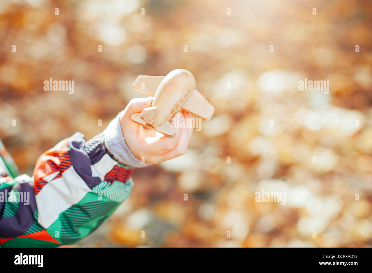 Little kid playing with wooden toy plane Stock Photo - Alamy