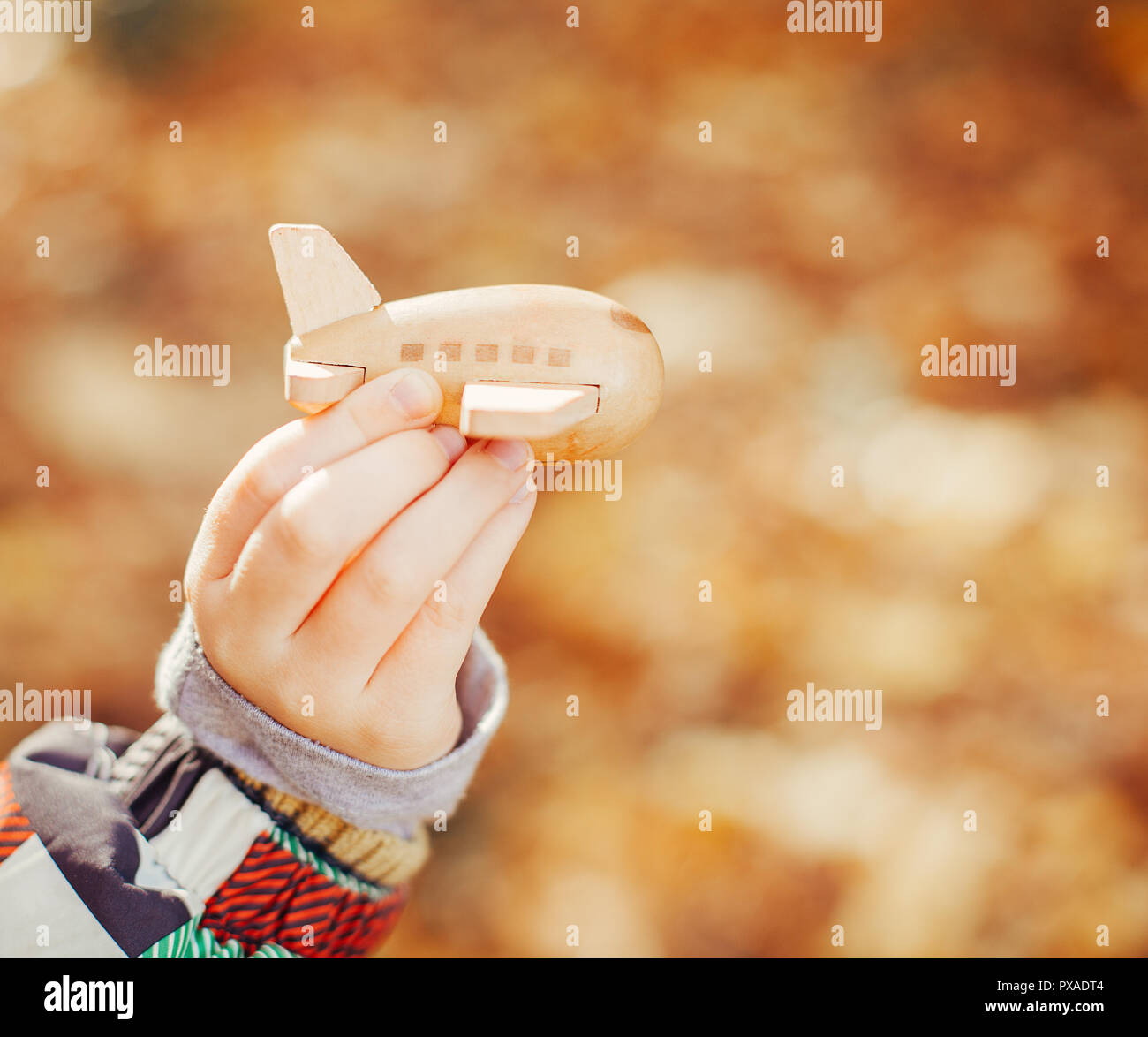 Little kid playing with wooden toy plane Stock Photo - Alamy