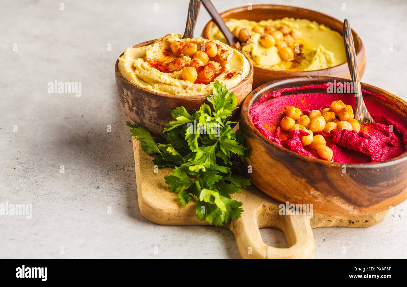 Different hummus bowls. Chickpea hummus, avocado hummus and beet hummus. Plant based diet food