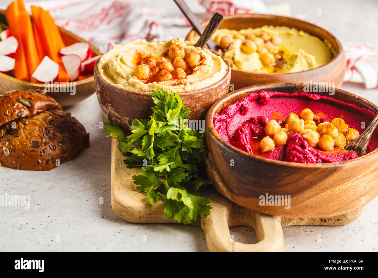Different hummus bowls. Chickpea hummus, avocado hummus and beet hummus. Plant based diet food