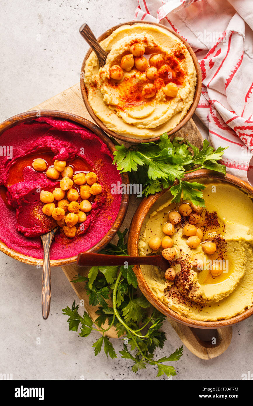 Different hummus bowls. Chickpea hummus, avocado hummus and beet hummus. Plant based diet food