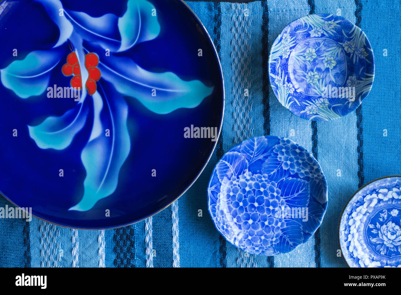 Blue and white plates on blue textured table cloth - top view photograph Stock Photo