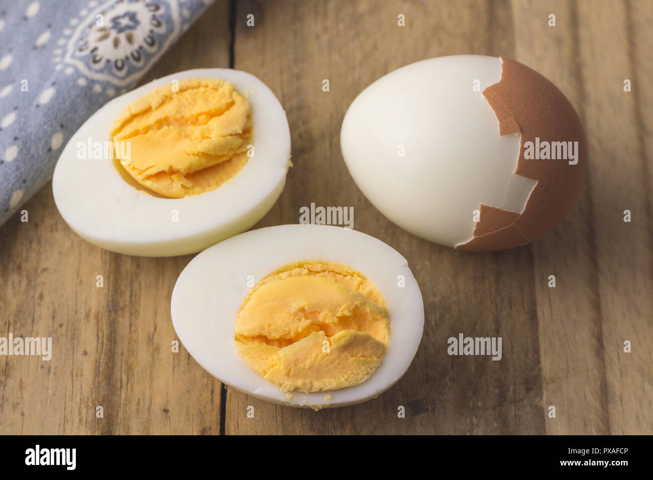 Boiled egg isolated on rustic wooden table - selective focus on hardboiled egg slice Stock Photo