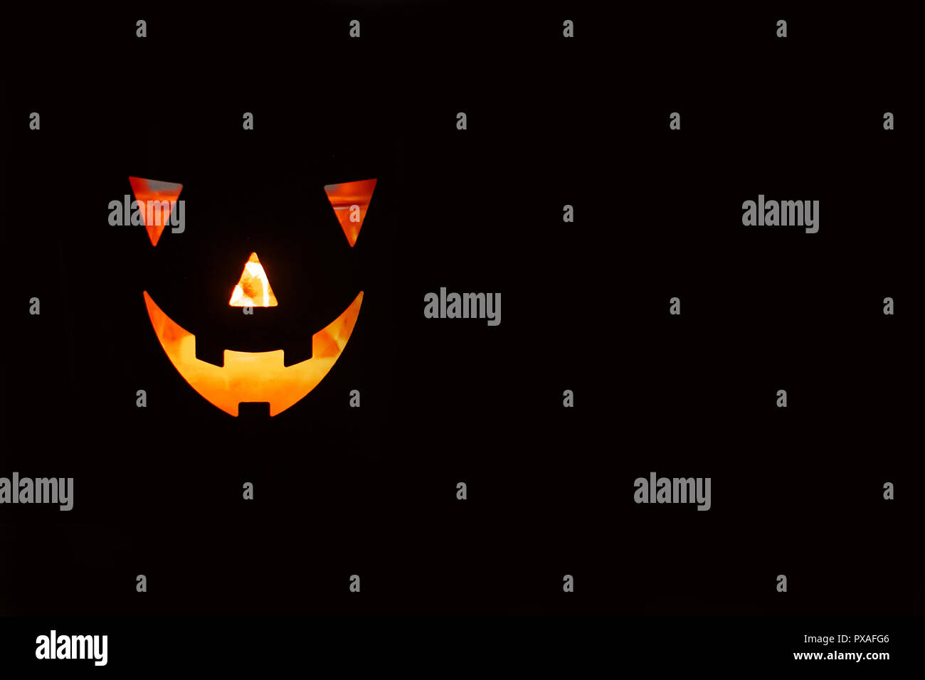 Halloween pumpkin with scary glowing face on black background isolated ...