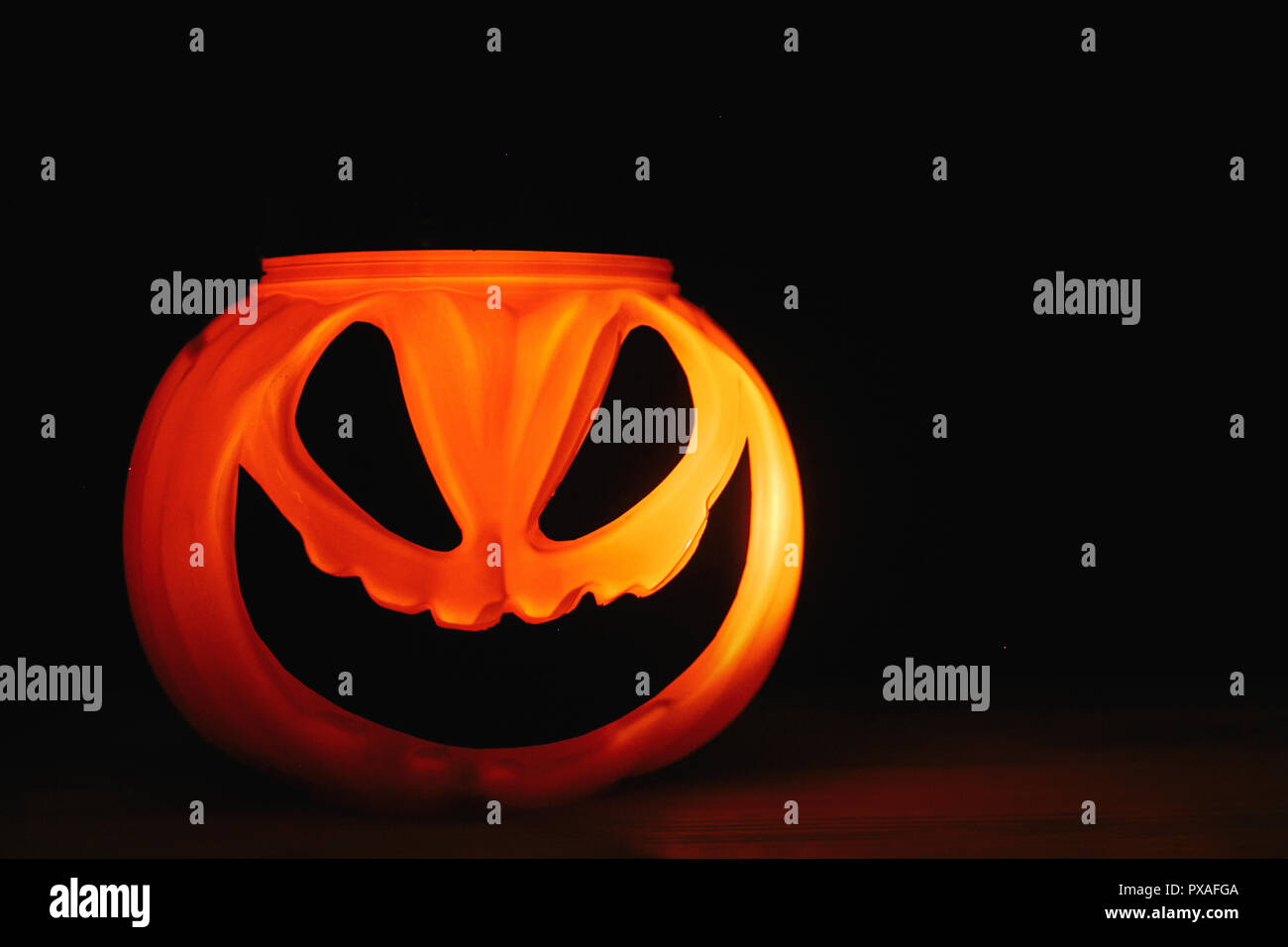 Halloween pumpkin Jack-o'-lantern with scary glowing face on black ...
