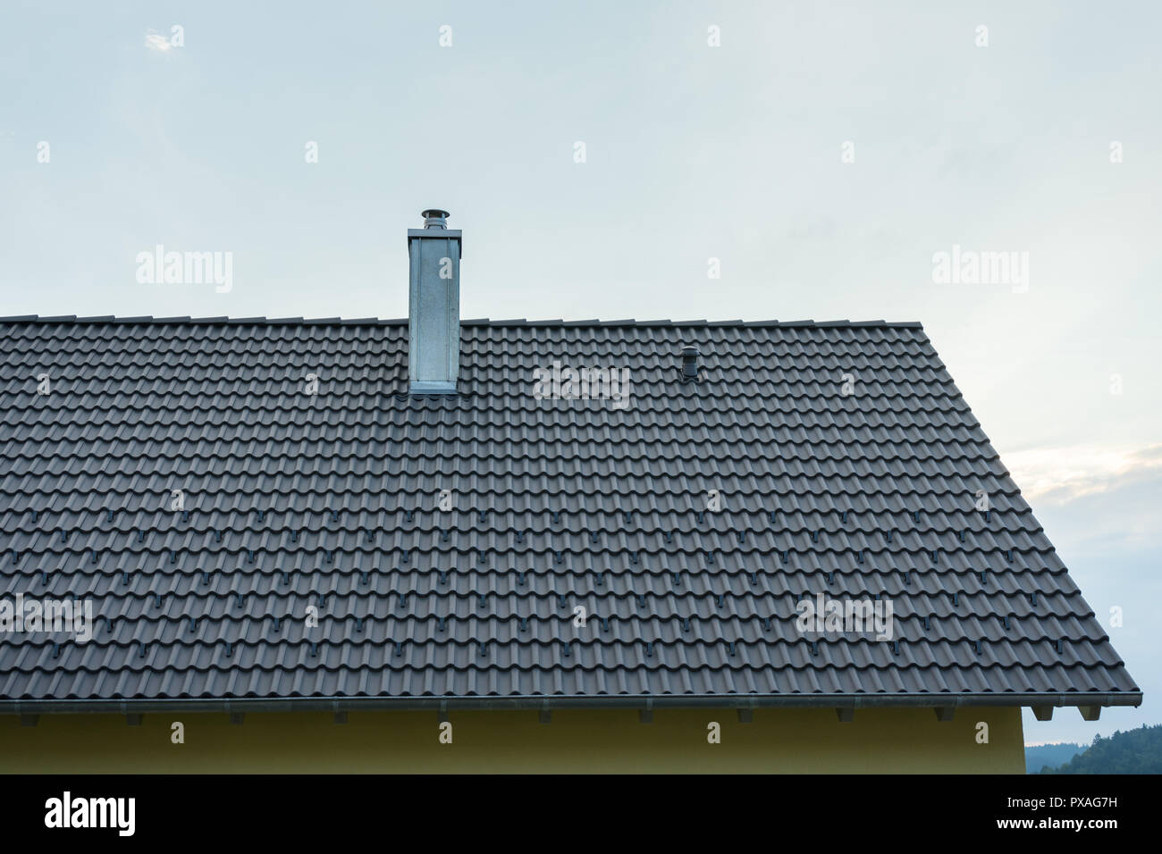 New building with dark roof tiles and chimney Stock Photo