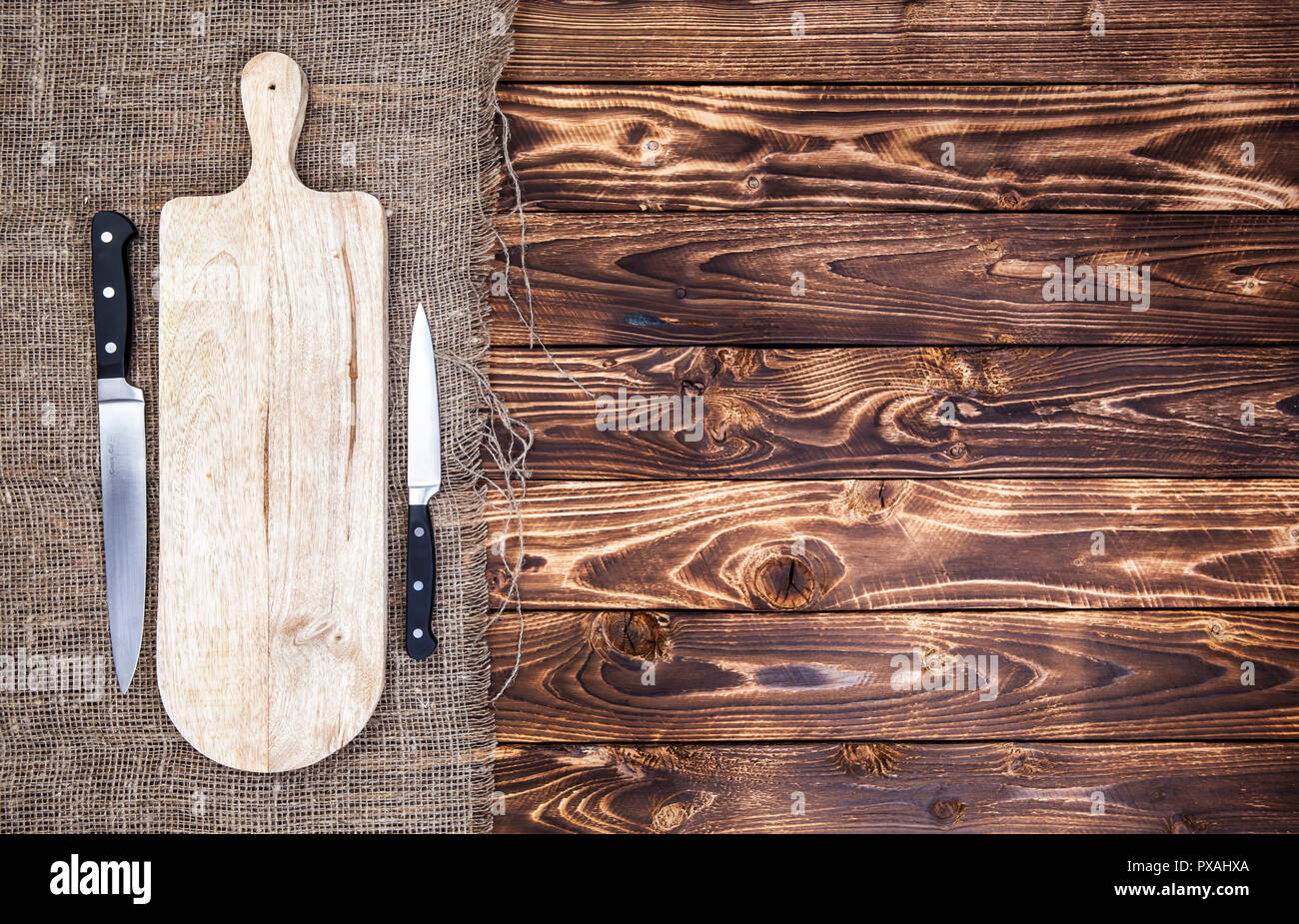https://c8.alamy.com/comp/PXAHXA/cutting-board-with-knife-on-dark-wooden-table-top-view-copy-space-PXAHXA.jpg
