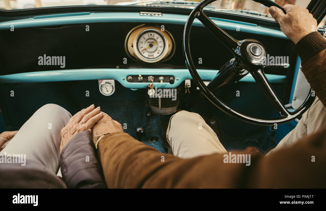 Close Up Of A Senior Couple Holding Hands While Driving A Car Old Man Driving The Car With Woman Sitting On Passenger Seat Holding His Hand Stock Photo Alamy