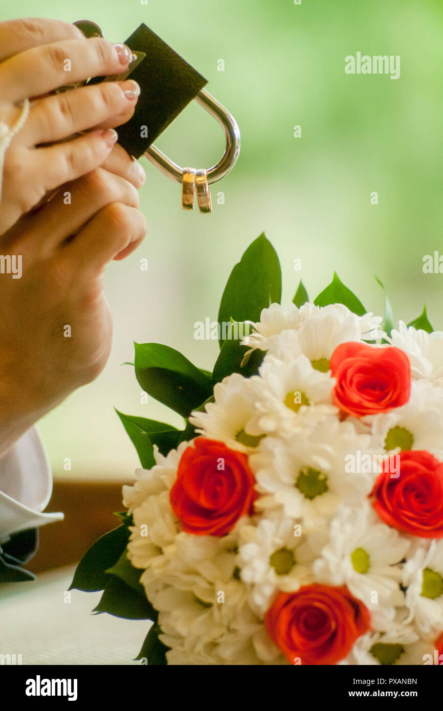 Gold wedding lock in couple's hands. Bride holding a bright wedding